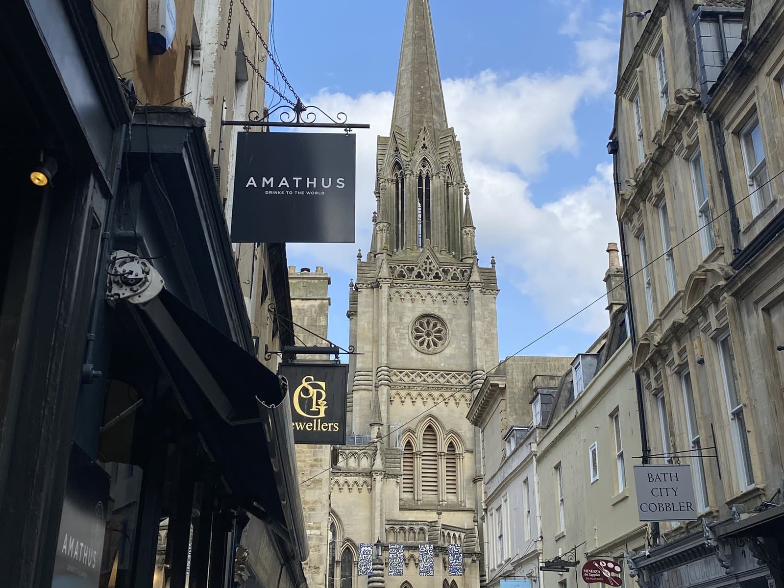 A Bath shopping street below the spire of St Michael's