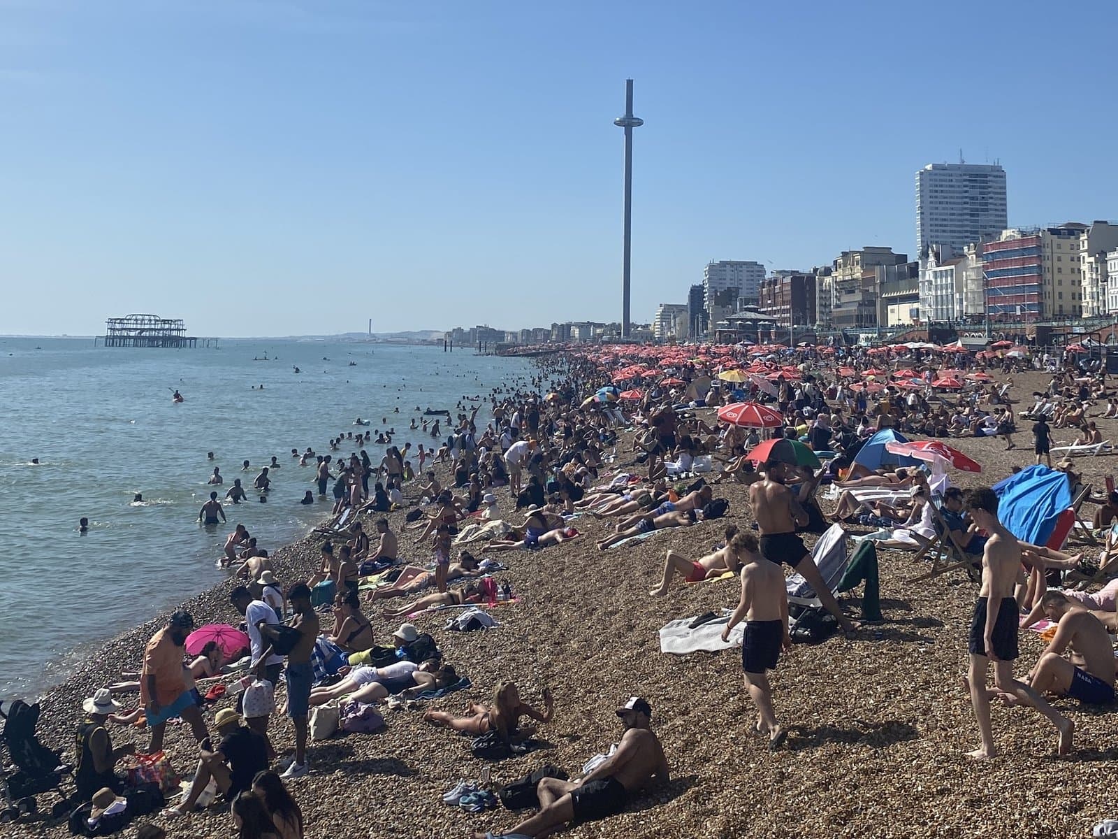 Brighton beach on a summer day, with the i360 behind