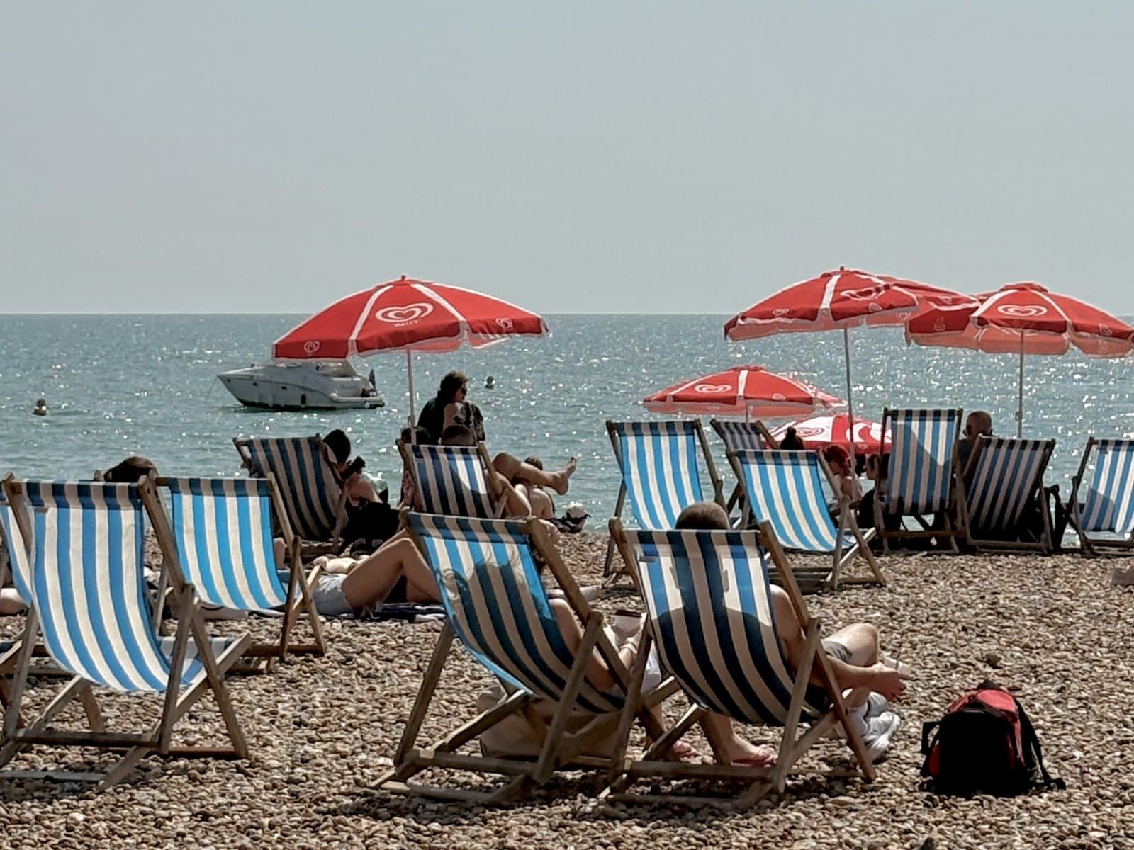 Deckchairs and red umbrellas on the shingle