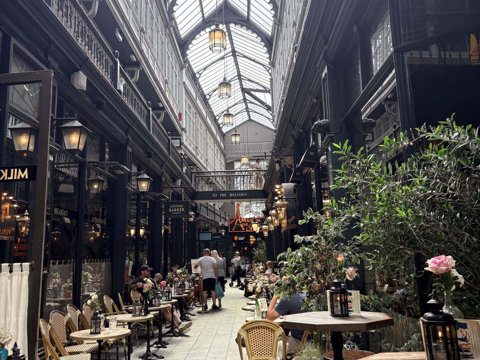Café tables under the glass roof of a Victorian arcade