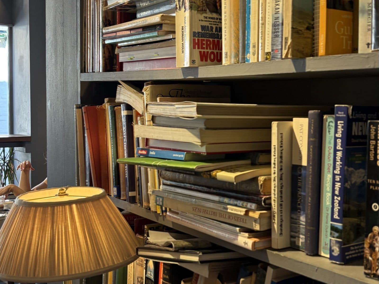 Stacked books and a reading lamp at Steep Street Coffee House